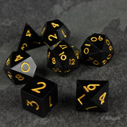 Midnight Sovereign Dice Set - Black polyhedral dice set with sharp edges and gold numbers, including d20, d12, d10, d8, d6, and d4.