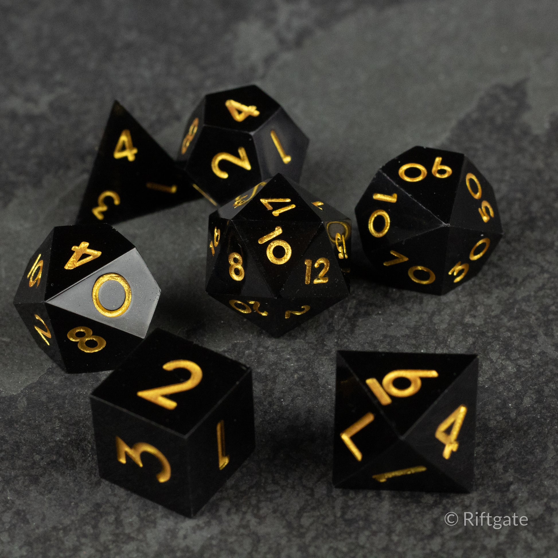 Midnight Sovereign Dice Set - Black polyhedral dice set with sharp edges and gold numbers, including d20, d12, d10, d8, d6, and d4.