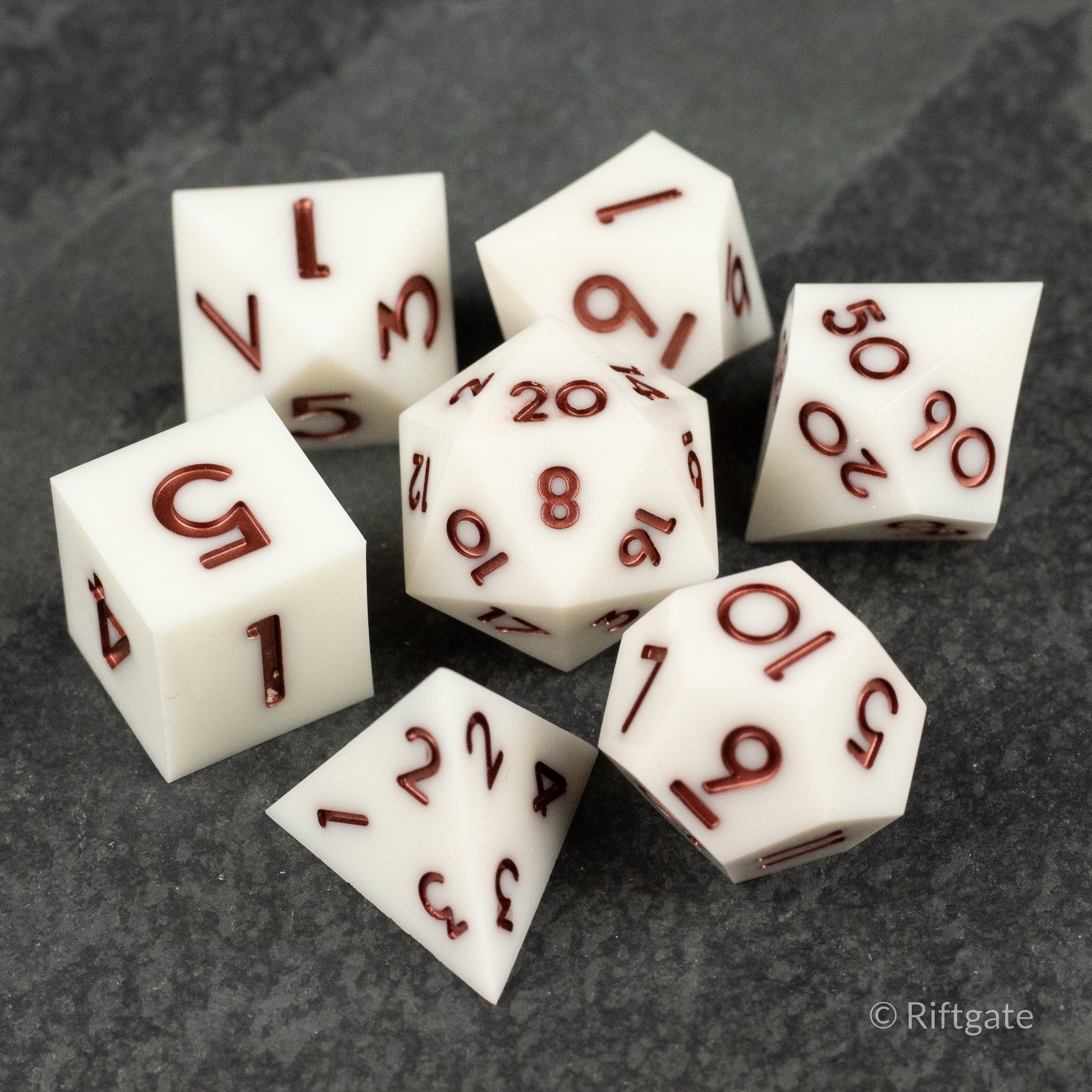 Glacial Spark Dice Set - Seven white polyhedral dice with sharp edges and red metallic numbers, including d4, d6, d8, d10, d12, and d20 designs.