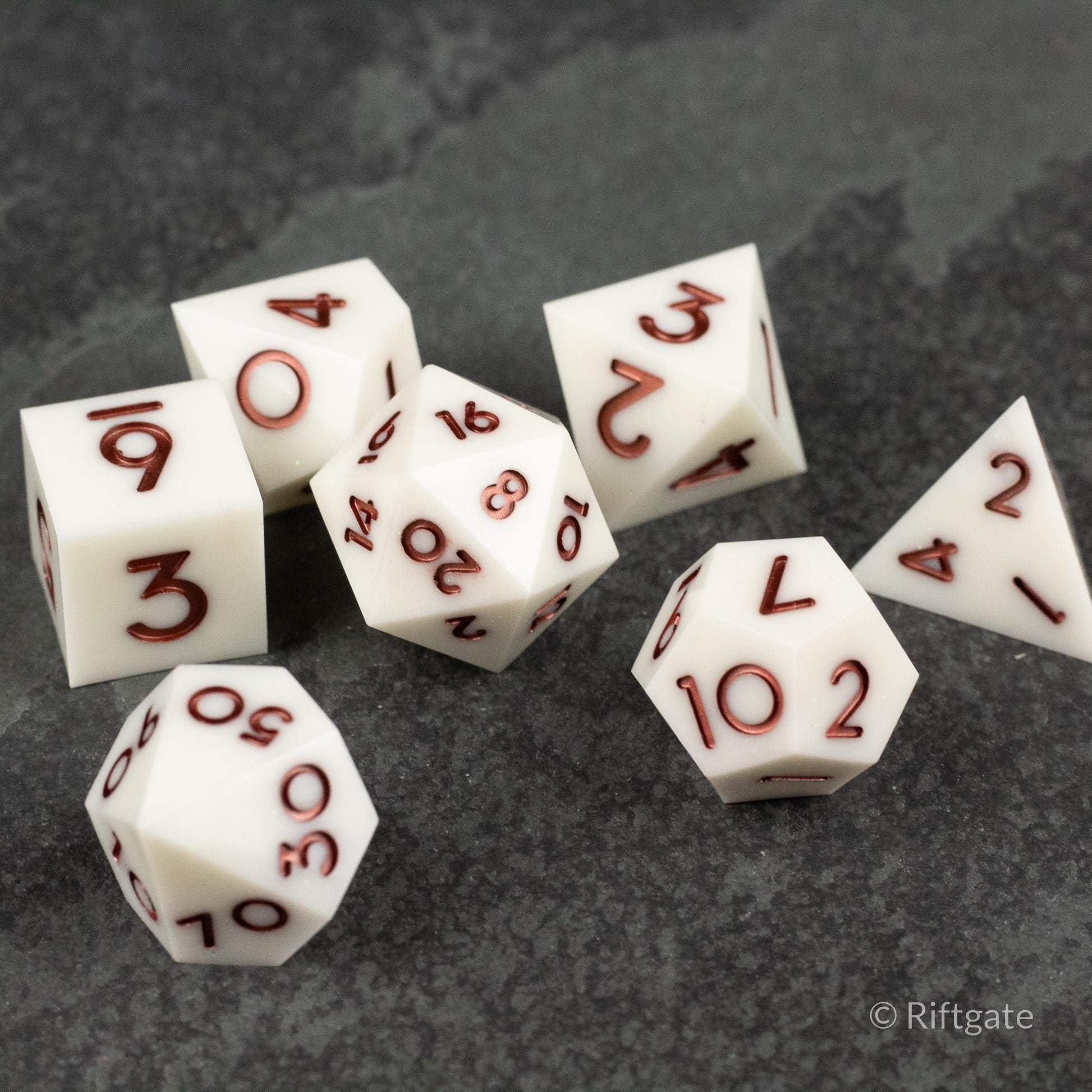 Glacial Spark Dice Set - Set of seven white polyhedral dice with sharp edges and deep red numbering, perfect for tabletop gaming.