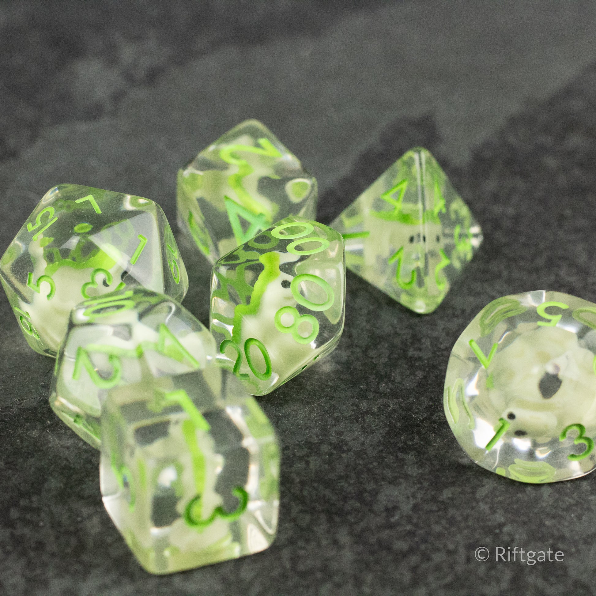 Green T-Rex Dice Set - Set of seven translucent green dice with black numbers, including various polyhedral shapes for tabletop gaming.