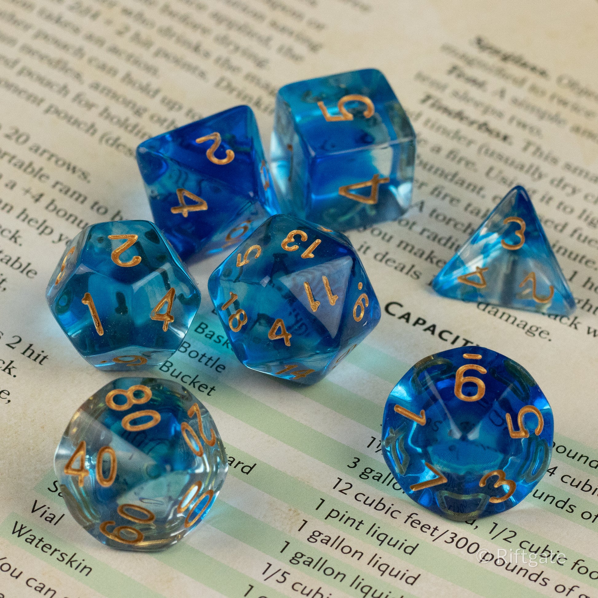Ethereal Mist Dice Set - Blue translucent polyhedral dice set with gold numbers, including d20, d12, d10, d8, d6, and d4.