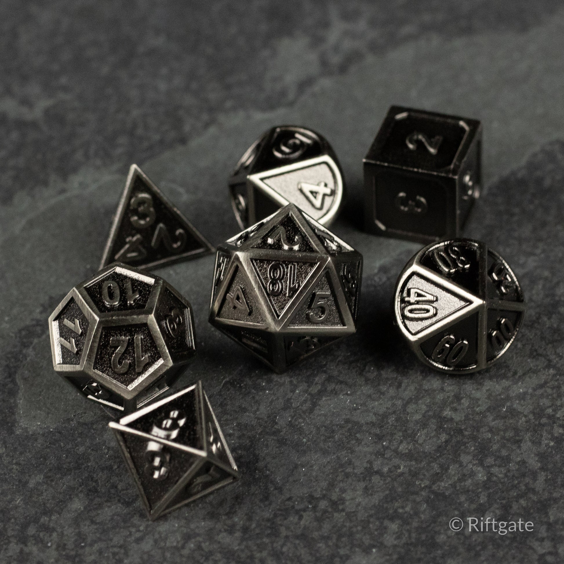 Shadowsteel Dice Set - Metallic gray seven-piece dice set with etched black numbers, including d4, d6, d8, d10, d12, d20, and percentile dice.