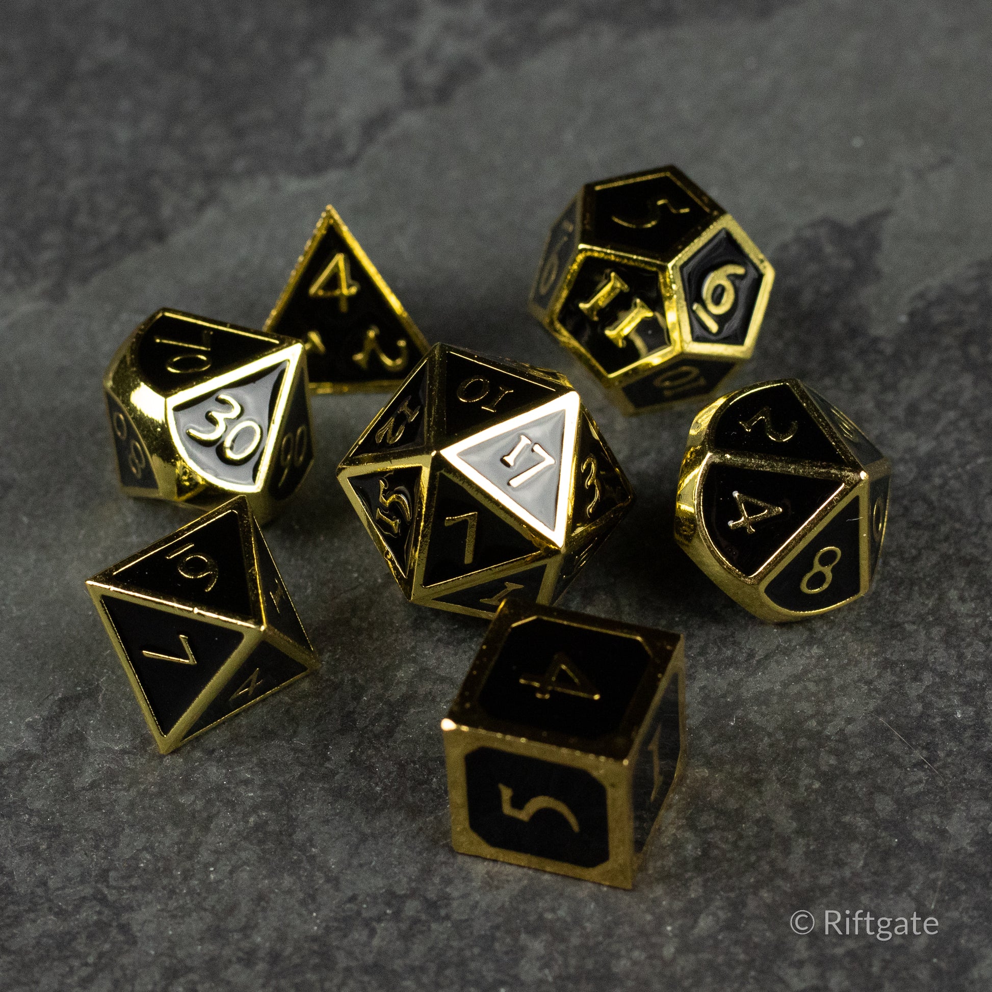 Aurum Eclipse Dice Set - Glossy black metal RPG dice set with gold edges and numbers, including d4, d6, d8, d10, d12, and d20 shapes.