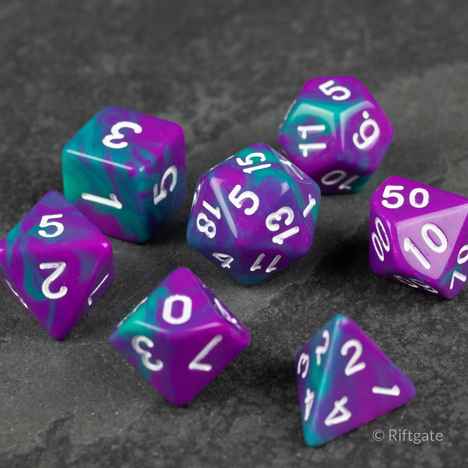 Purple and Turquoise Marbled Dice Set - Set of seven purple and turquoise marbled gaming dice with white numbers on a dark textured surface.