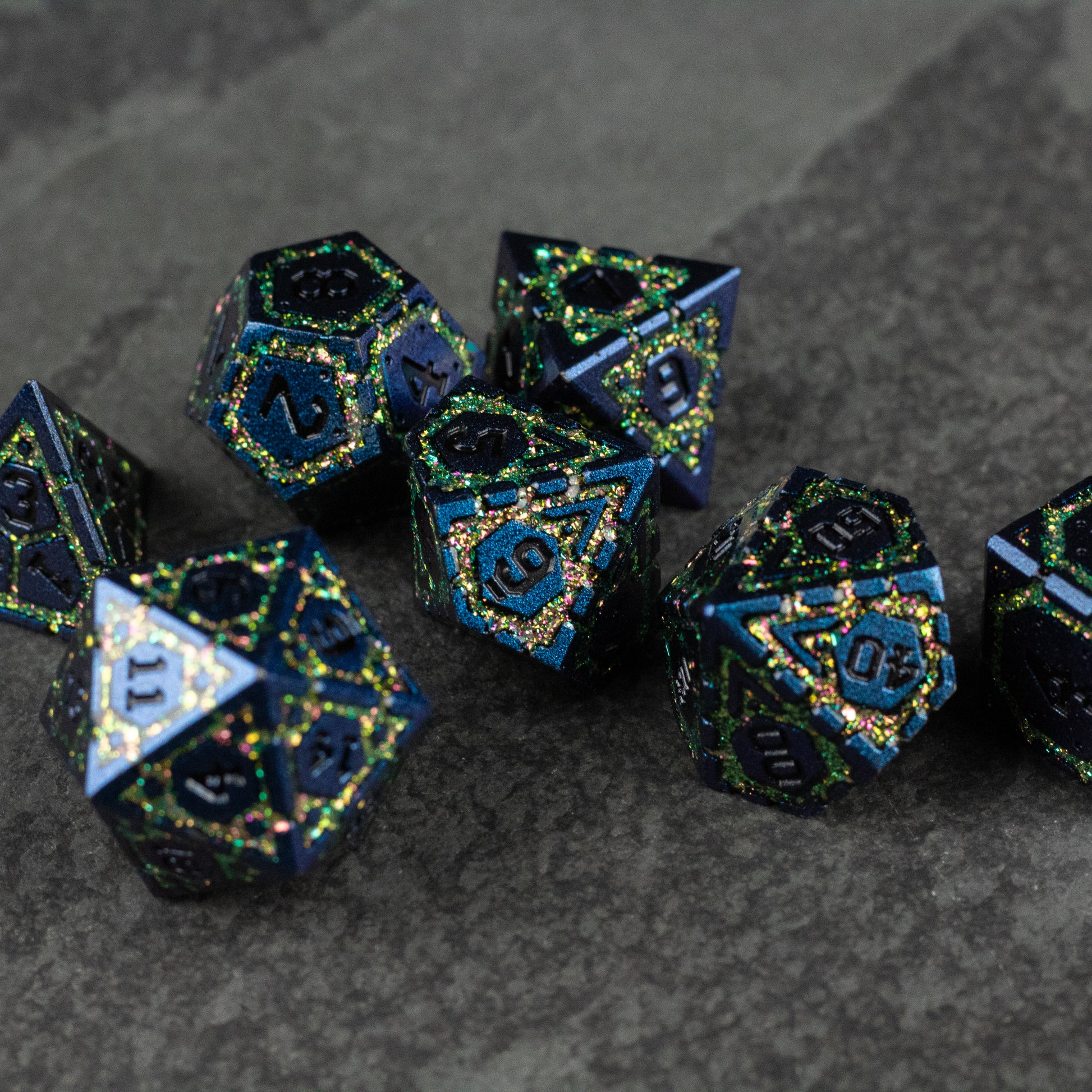 Green Superior Ward Metal Dice Set - Set of dark green metal polyhedral dice with intricate blue and gold accents, including d20, d12, d10, d8, d6, and d4 shapes.