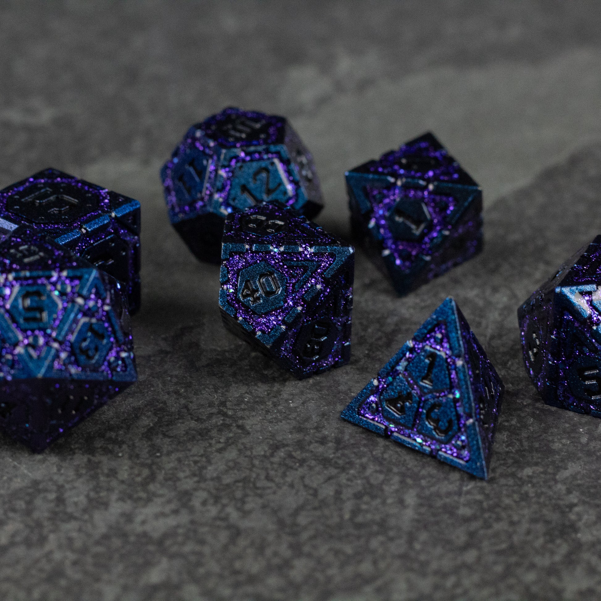Purple Superior Ward Metal Dice Set - Set of seven metallic purple polyhedral dice with bright blue numbering on a dark gray textured surface.