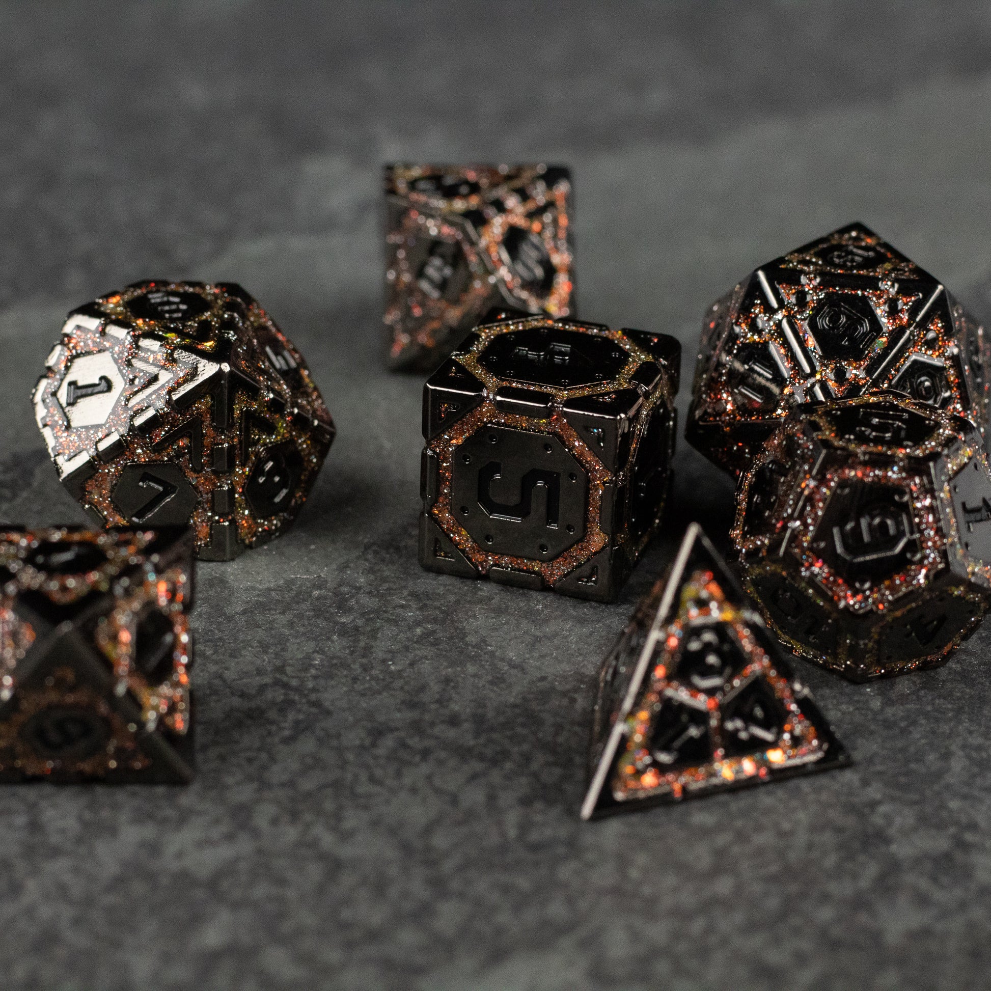 Gold Arcane Ward Metal Dice Set - Gold and black metal polyhedral dice set with intricate arcane-style engravings on a dark textured surface.