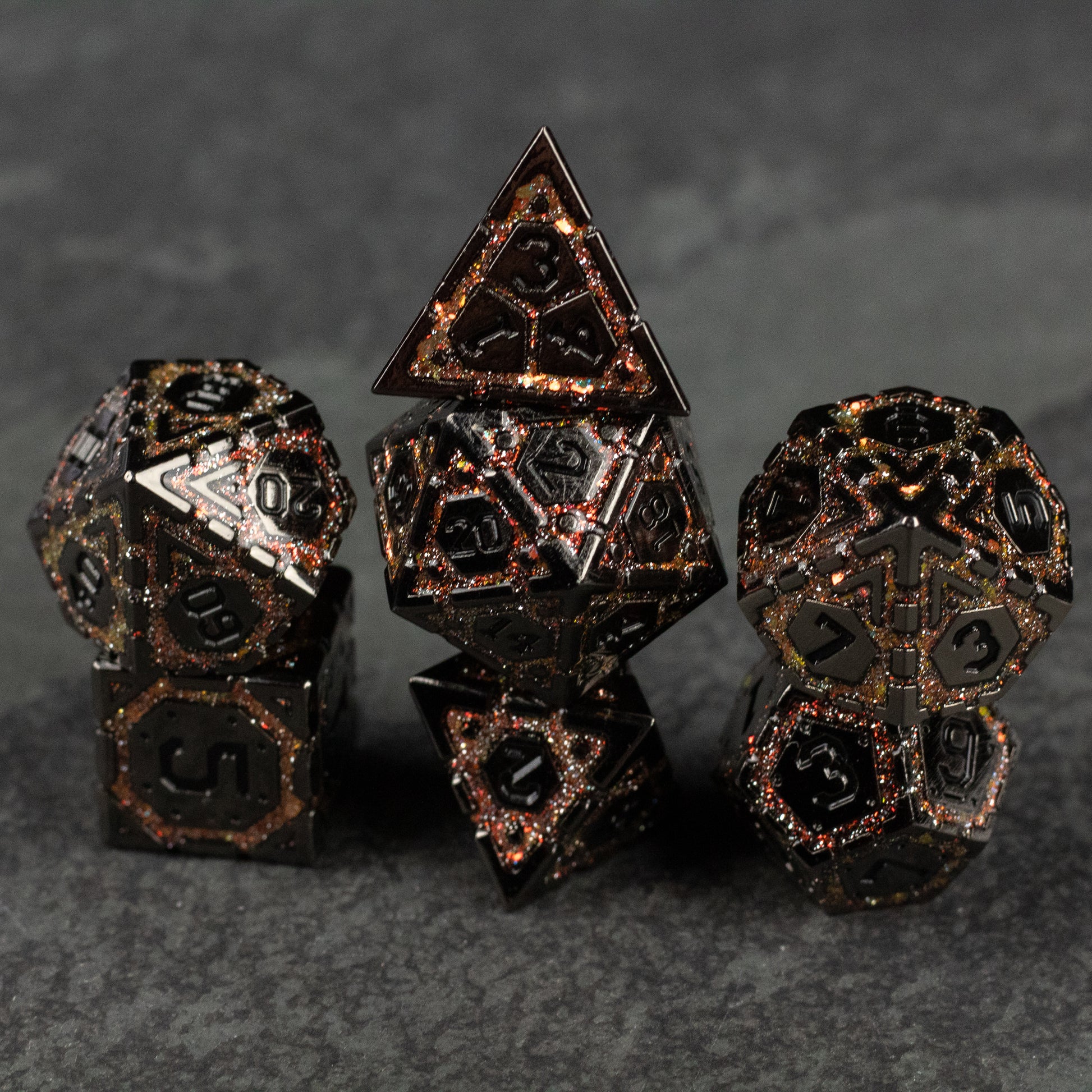 Gold Arcane Ward Metal Dice Set - Set of seven black metal polyhedral dice with intricate gold geometric and arcane patterns etched on each face.