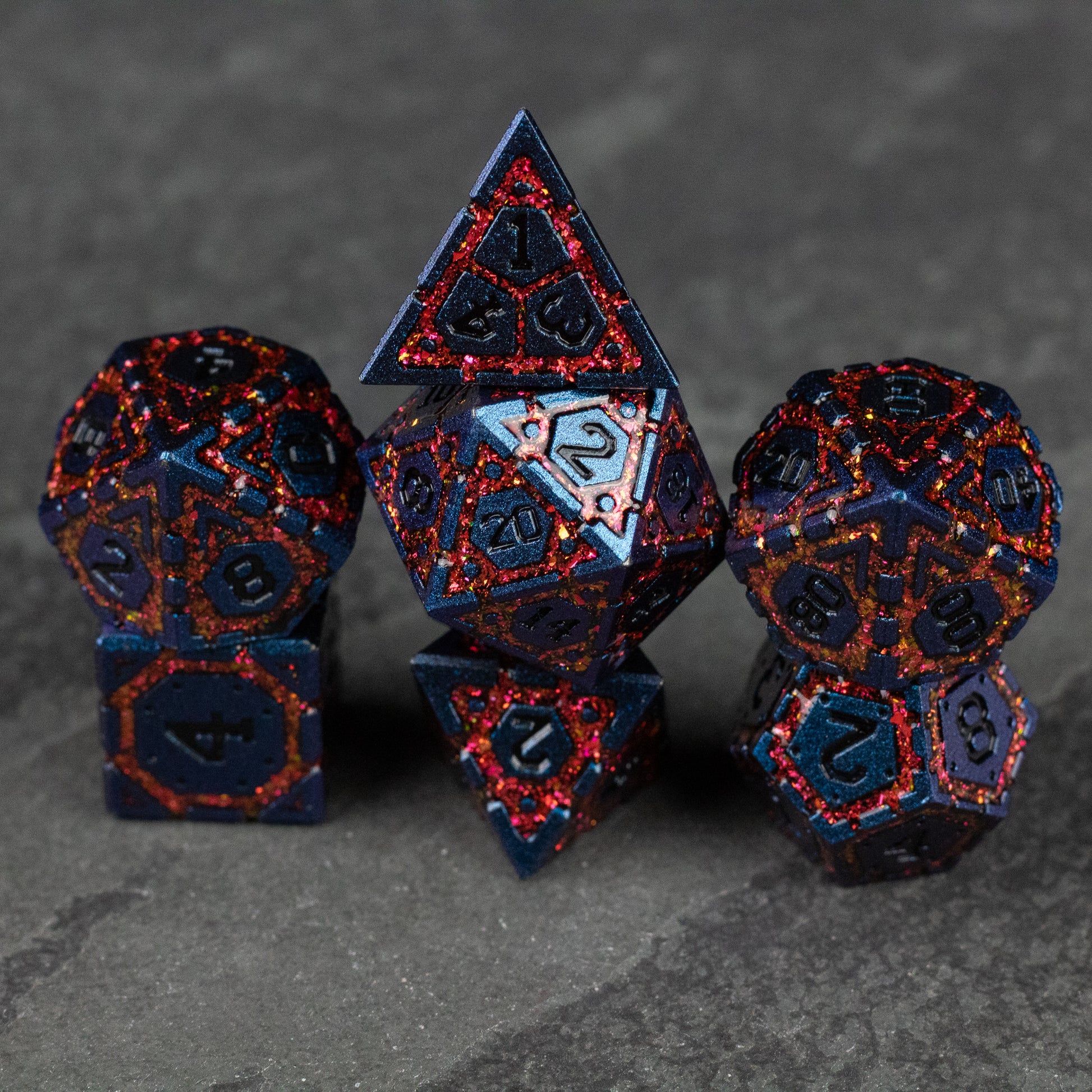 Red Superior Ward Metal Dice Set - Set of red metal polyhedral dice with black numbering and fiery textured patterns.