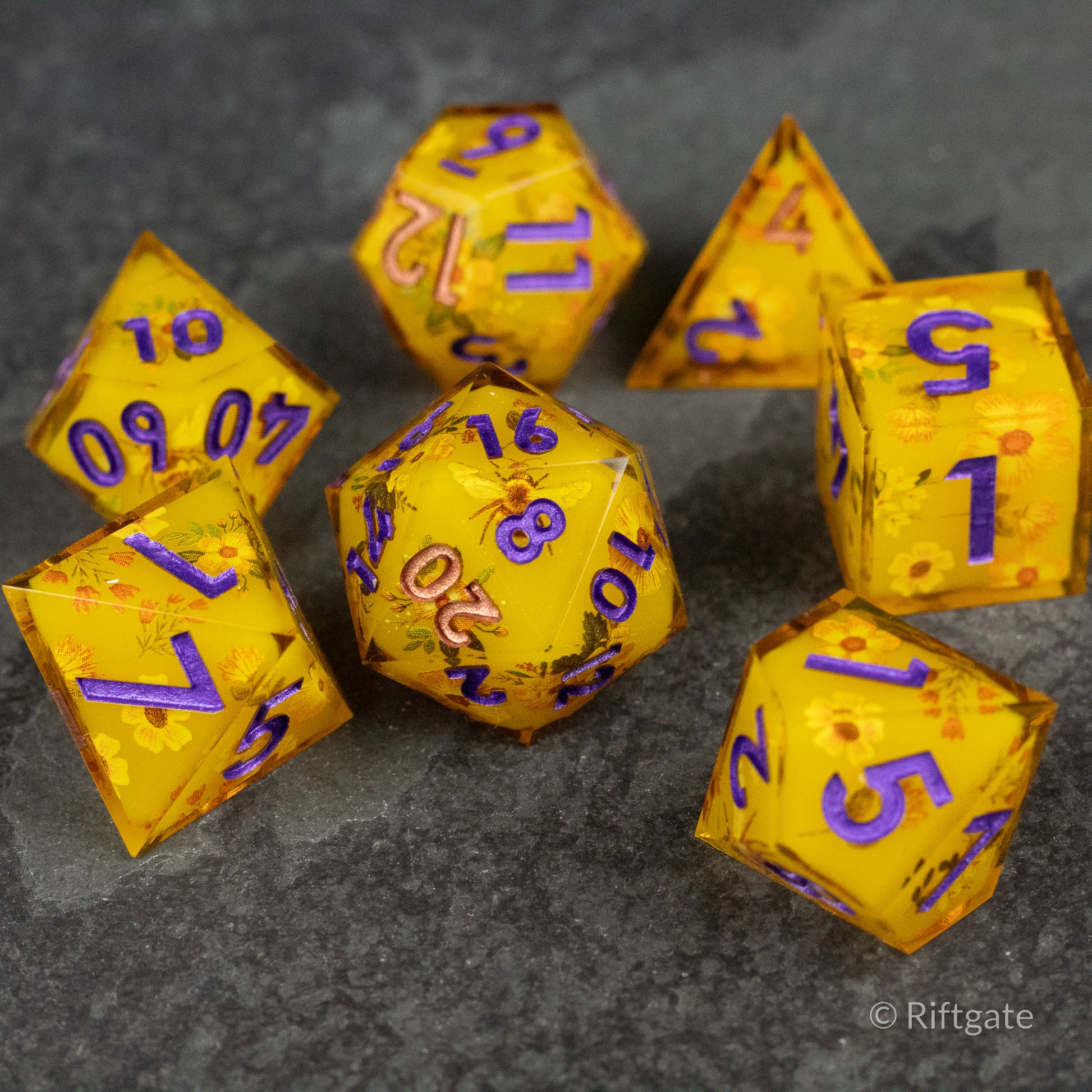 Honey Bees and Flowers Sharp Edge Dice - Honey-colored sharp edge polyhedral dice set with purple numbers and honey bee and flower designs.