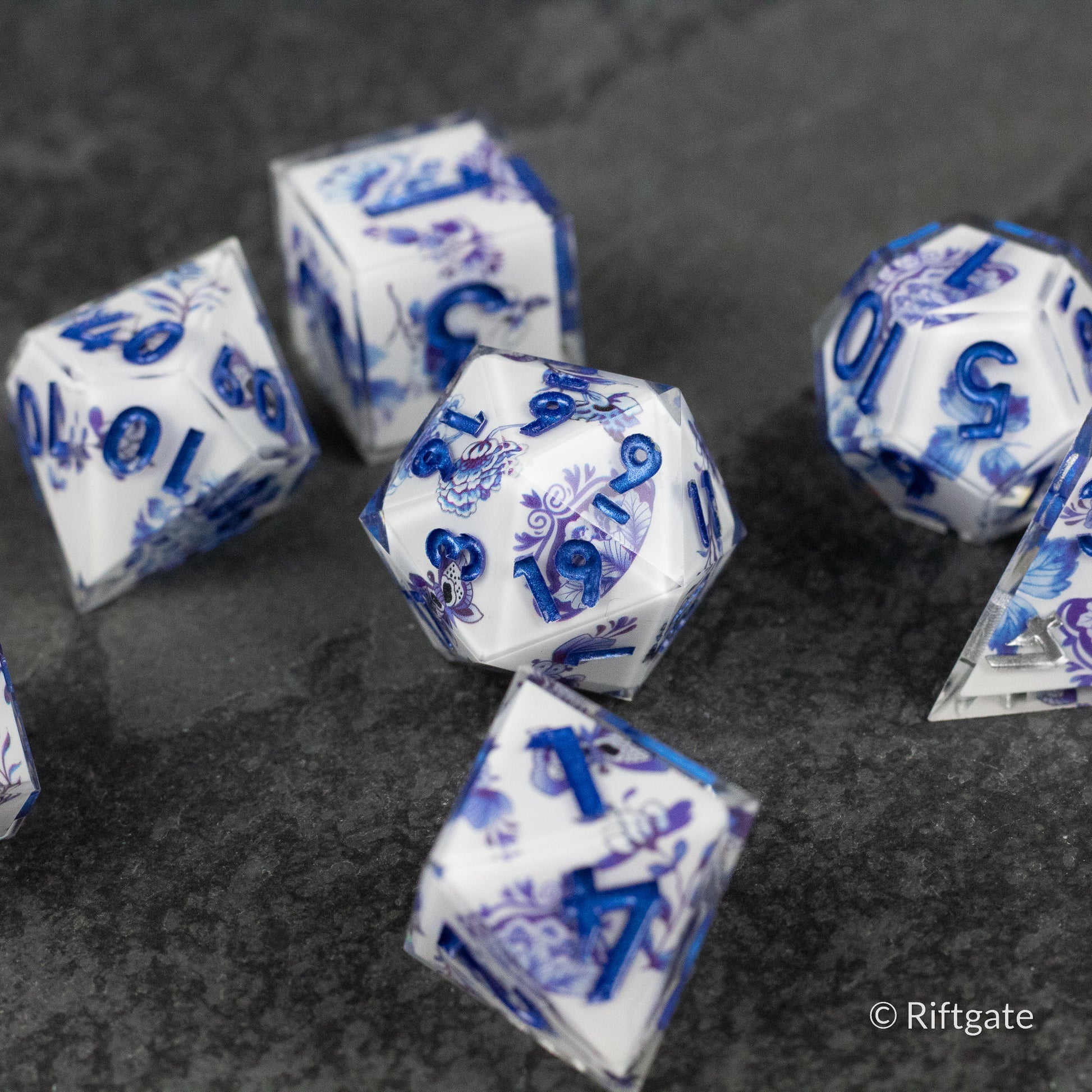 Moonlight Garden Dice Set - White polyhedral dice set with deep blue floral designs and numbers on each face, glossy finish.