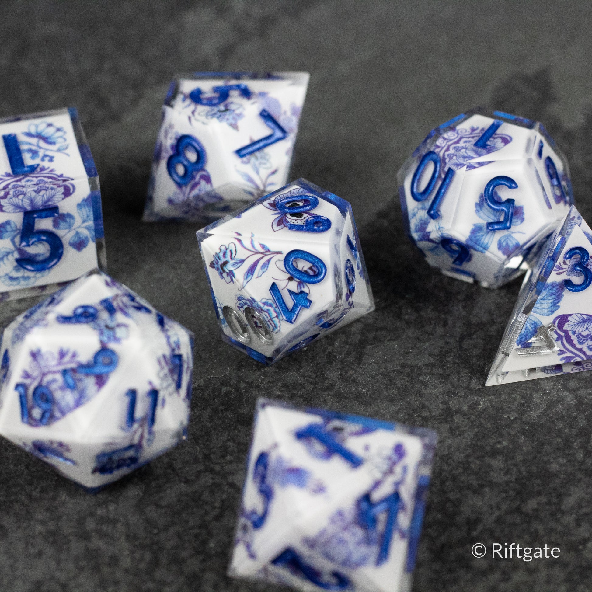 Moonlight Garden Dice Set - White polyhedral dice set with intricate blue floral and moon designs, translucent edges, including D20, D12, D10, D8, D6,.