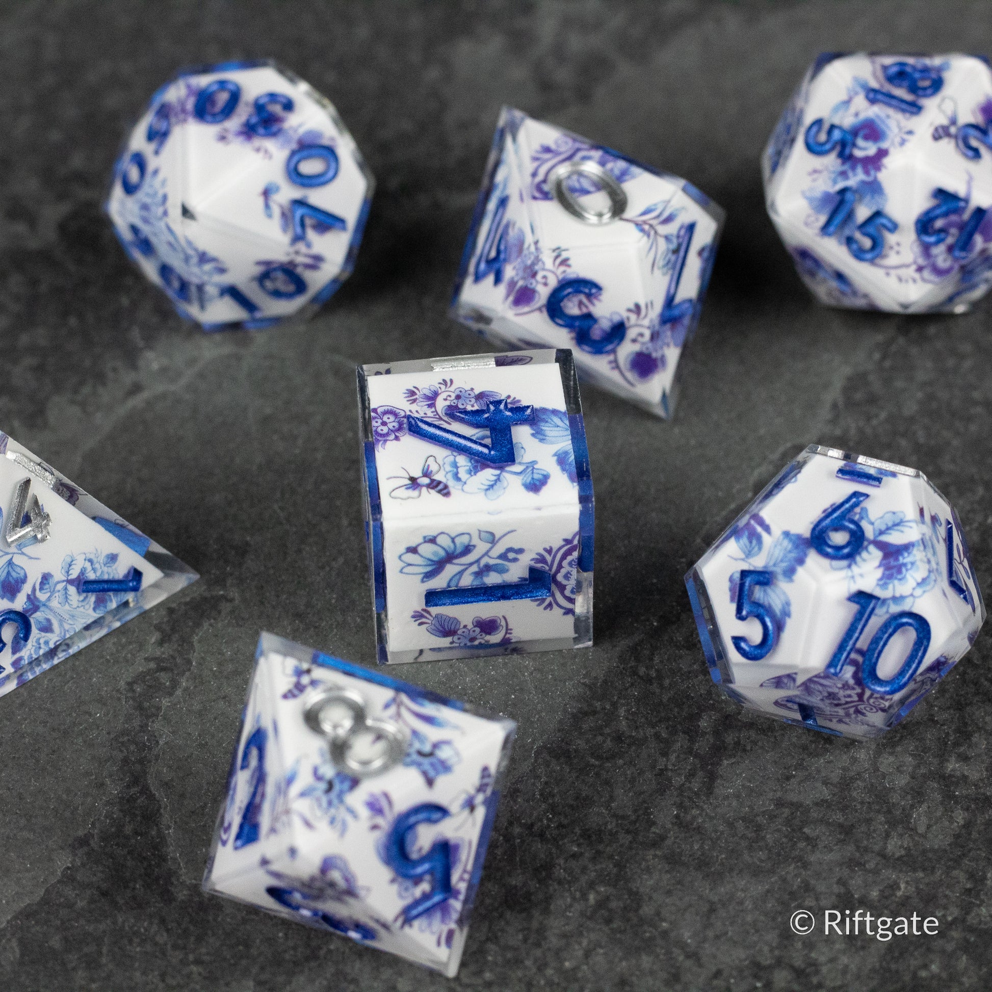Moonlight Garden Dice Set - Translucent white polyhedral dice with deep blue celestial-themed numbers and symbols, including stars and moons.