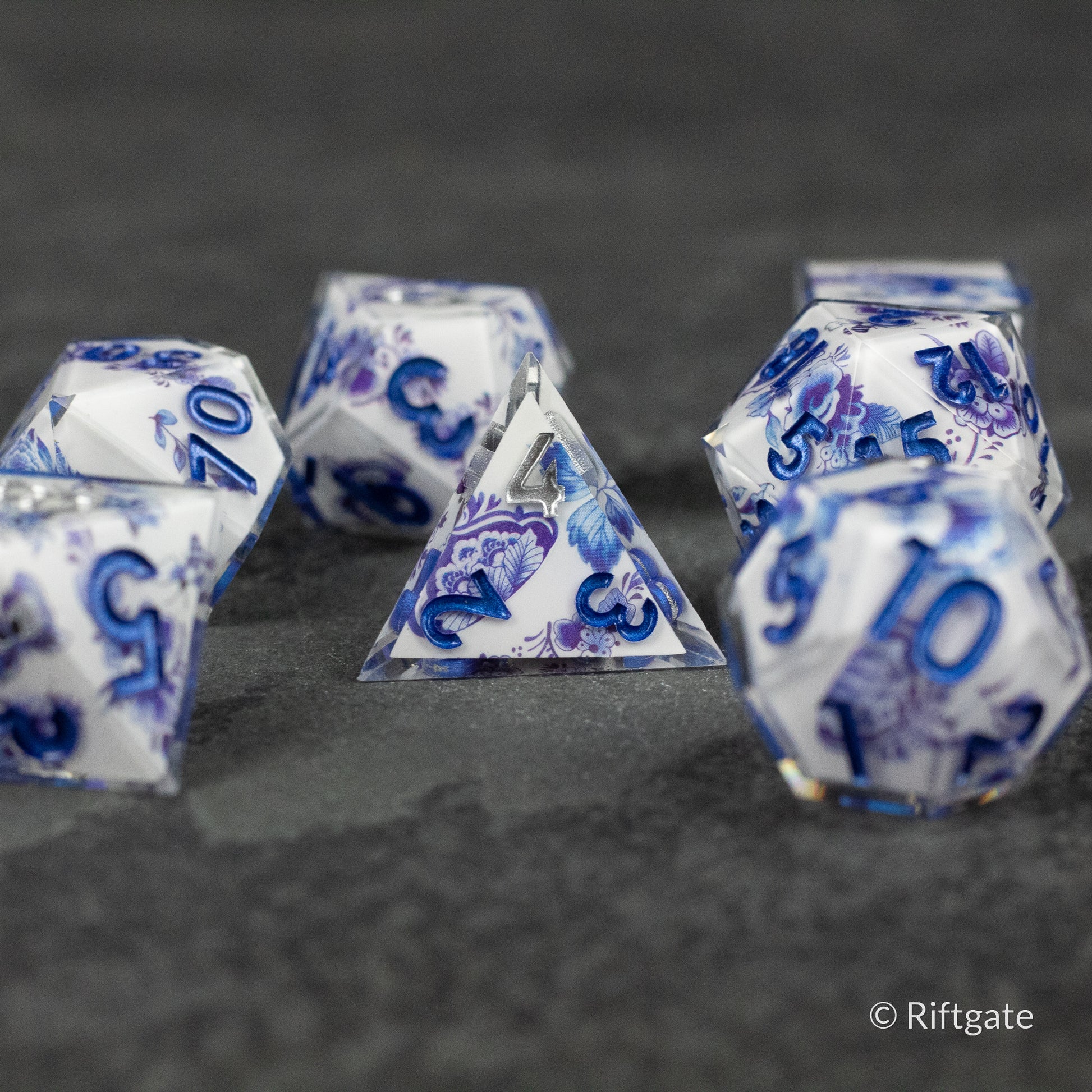 Moonlight Garden Dice Set - Translucent white polyhedral dice set with deep blue swirling patterns and white numbers.