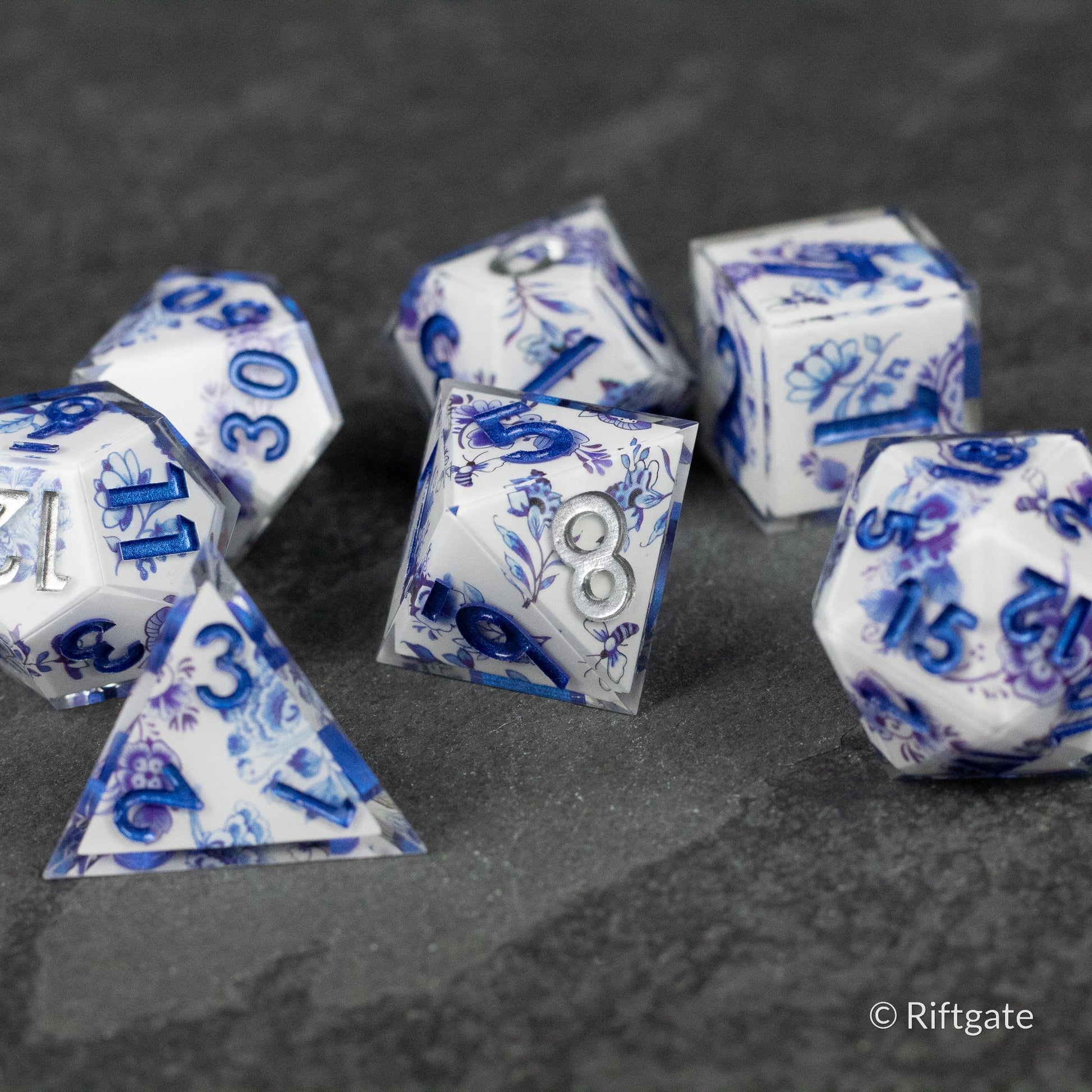 Moonlight Garden Dice Set - White polyhedral dice set with deep blue numbers and intricate blue floral and moonlight-themed designs.