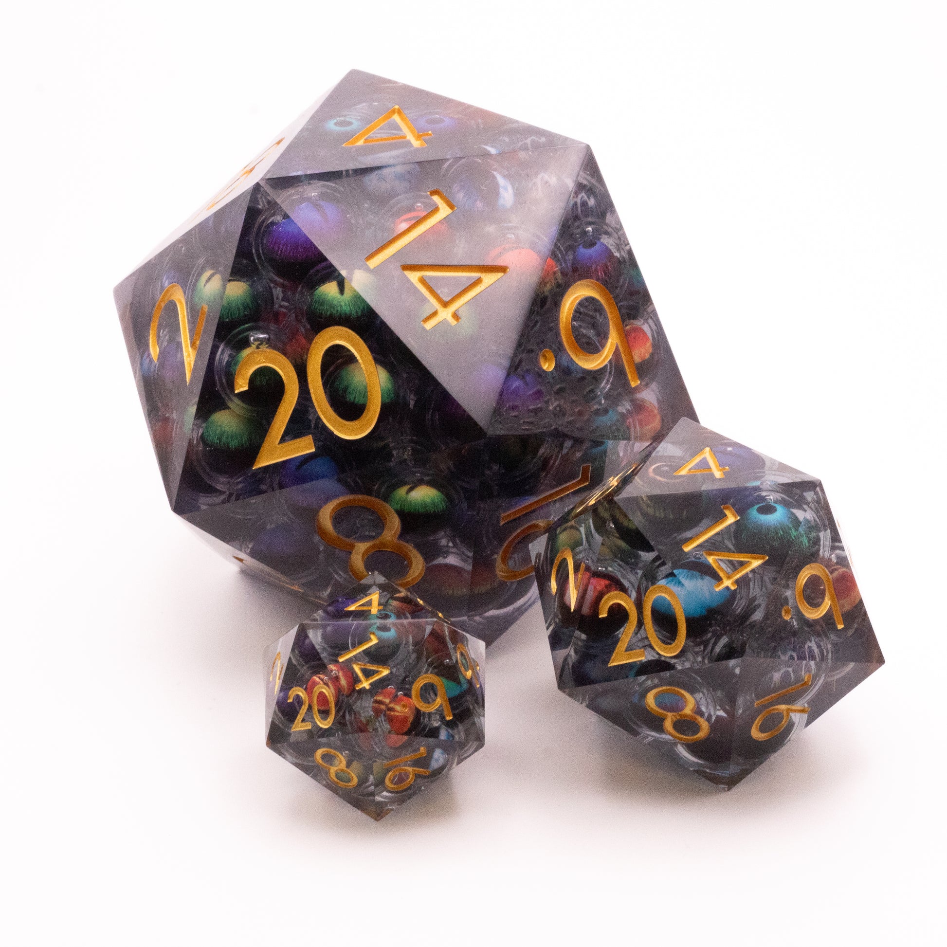 Giant Thousand Eyes D20 - Three translucent d20 dice with a purple and green marbled core and orange numbers, varying sizes shown.