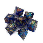 Constellation Sharp Edge Dice Set - Set of seven sharp-edged polyhedral dice in deep blue with gold constellation patterns and numbers.