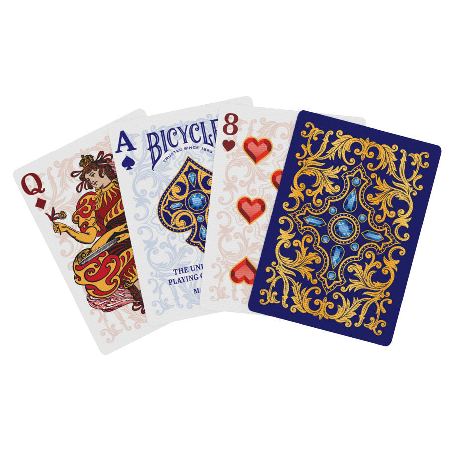 Bicycle Playing Cards: Royal (PREORDER) - Bicycle playing cards fanned out showing Queen of Hearts, Ace of Spades, Eight of Hearts, and blue back with ornate gold.