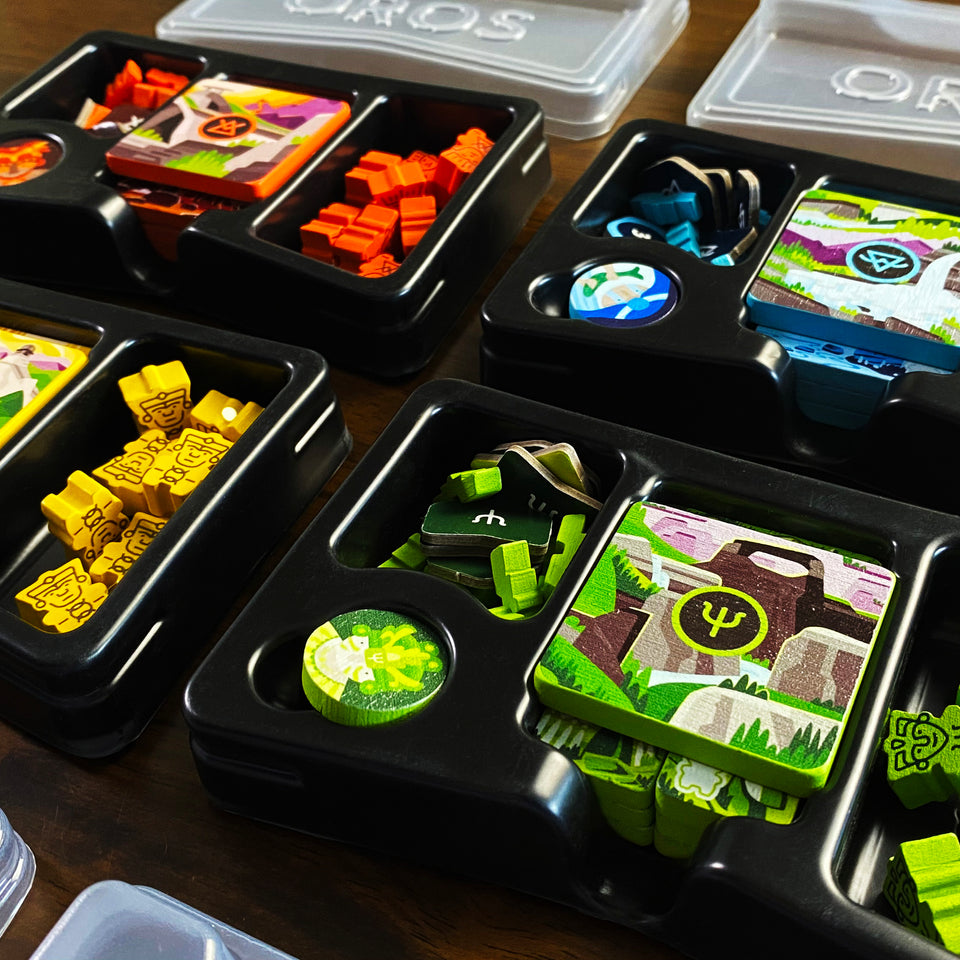 Oros Collector's Edition - Board game set with colorful tokens, cards, and custom containers in a divided black tray.