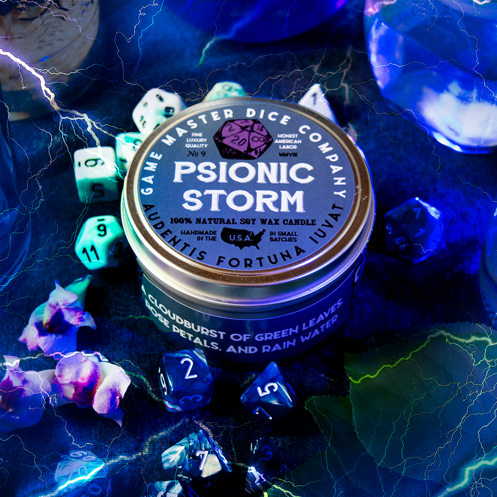 Psionic Storm Gaming Candle - Round blue candle tin with purple dice logo labeled Psionic Storm surrounded by colorful gaming dice on a dark.