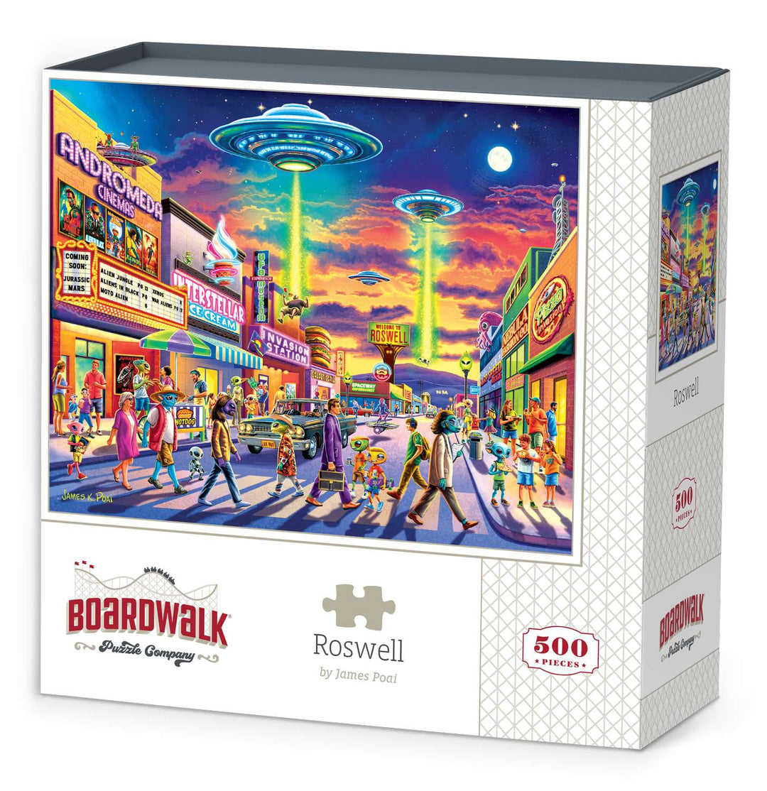Boardwalk 500 Piece Puzzle: Roswell - Colorful 500-piece puzzle box featuring a vibrant retro street scene with UFOs over Roswell at sunset.