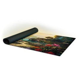 Sorcery: Contested Realm - Arthurian Legends Playmat - Valley of Delight - Rolled black gaming playmat featuring a colorful Arthurian-themed fantasy landscape with lush greenery and vibrant flowers.