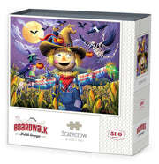 Boardwalk 500 Piece Puzzle: Scarecrow - Colorful autumn scarecrow wearing a blue shirt and red bandana in a moonlit cornfield with flying crows and a pumpkin on its