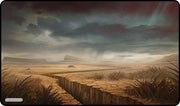 Gamermats Playmat: Magic Plains (PREORDER) - Fantasy-themed playmat with cracked earth, dry grass, and cloudy, moody sky in muted brown tones.