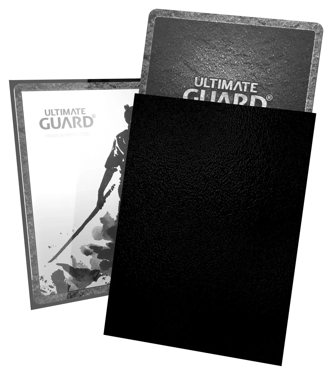 Ultimate Guard Katana 100 ct Standard Sleeves - Black - Black matte card sleeve positioned in front of two Ultimate Guard card packaging featuring a warrior silhouette and textured