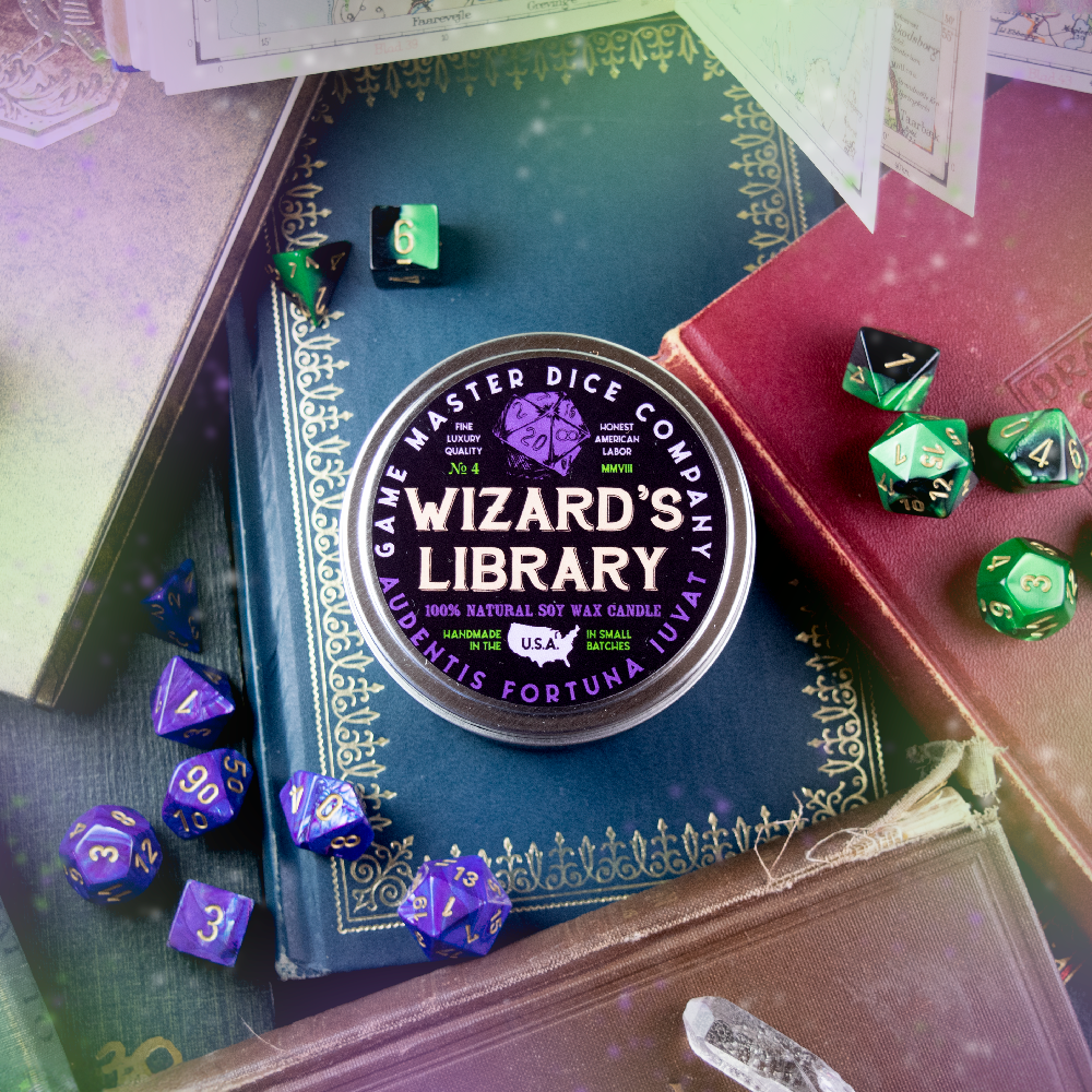 Wizard's Library Gaming Candle - Round purple candle tin labeled Wizard's Library by Celestial Dice Company, surrounded by green and purple polyhedral dice.