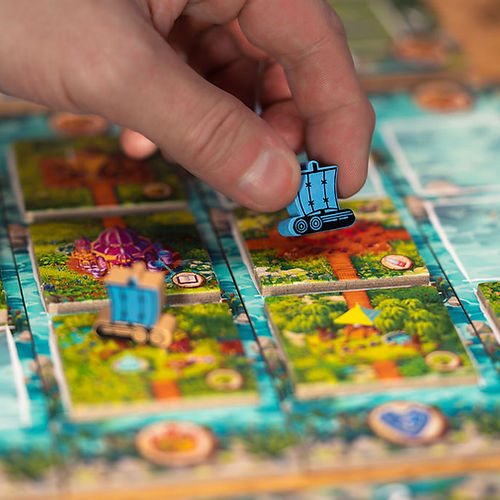 Timber Town - Blue wooden train tokens placed on a colorful board with illustrated forest and track tiles.