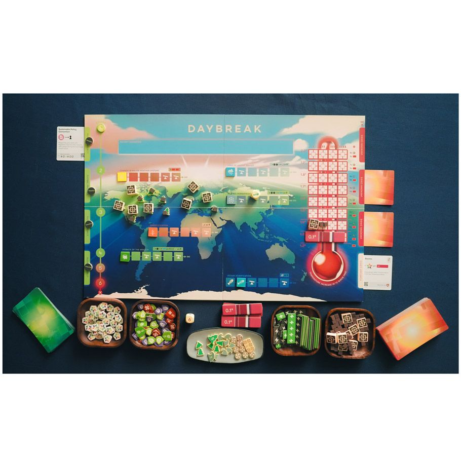 Daybreak - Colorful cooperative board game featuring a world map, cards, tokens, and wooden pieces on a blue background.