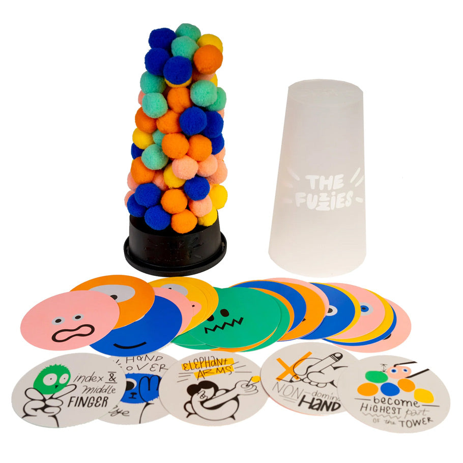 The Fuzzies - Colorful soft fuzzy balls stacked on a black base next to a white translucent cup and round illustrated game cards with.