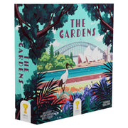 The Gardens - Square board game box with colorful illustrated garden scene, featuring a crane, tropical plants, and city skyline backdrop.