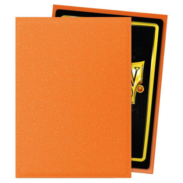 Dragon Shield: Matte: Amber (100) - Matte amber card sleeve with solid color and smooth texture, holding a standard playing card.