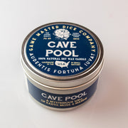 Cave Pool Gaming Candle - Round metal tin candle with navy blue label, white text, and logo featuring a 20-sided die design.