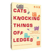 Cats Knocking Things off Ledges - Beige rectangular box with red and teal cartoon cats, bold red text, and playful design for a dexterity party game.