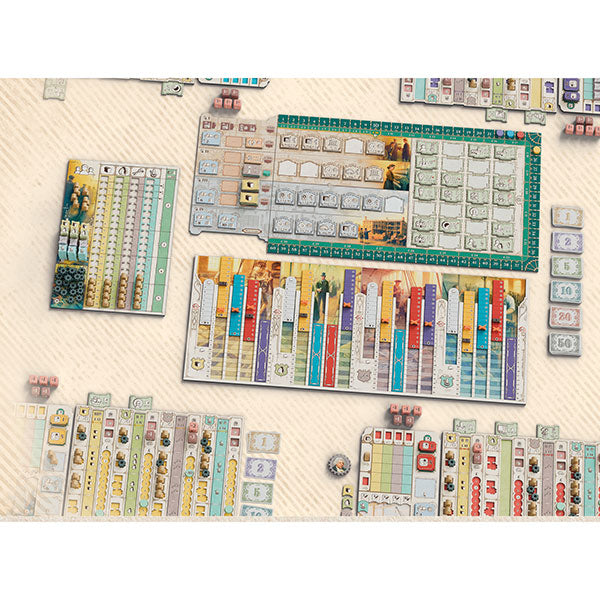 Arkwright: Anniversary - Board game setup showing colorful rectangular player boards with various icons, numbers, and text spaces on a light wooden.