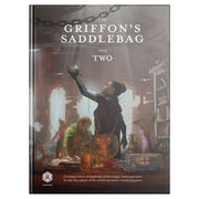 D&D 5E: The Griffon's Saddlebag Book Two - Fantasy-themed RPG book cover with two adventurers in a dimly lit workshop, warm brown and orange tones.