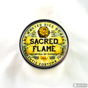 Sacred Flame Gaming Candle - Round metal tin candle with bright yellow flower background and bold black text reading Sacred Flame and decorative gamer.
