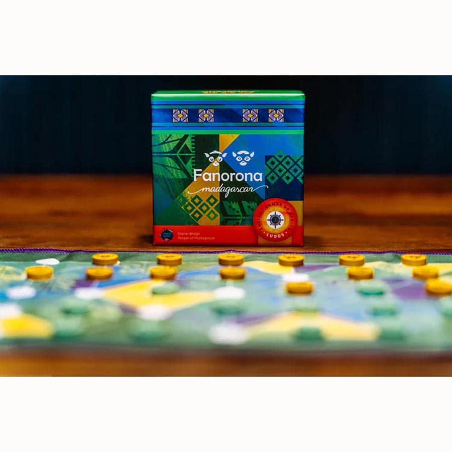 Ludos Africa Collection - Colorful wooden Ludos board with yellow and purple round playing pieces and a vibrant patterned game box labeled Fanorana.