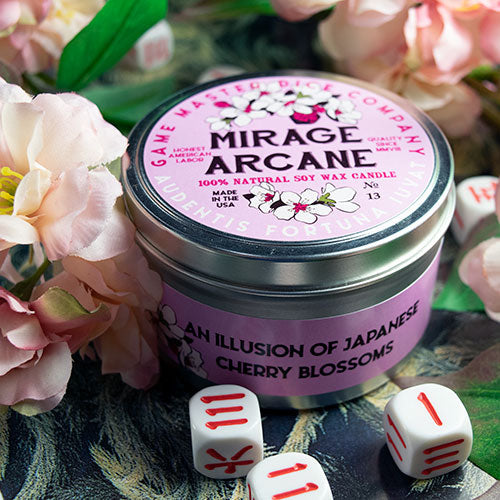 Mirage Arcane Gaming Candle - Round metal tin candle with pink label decorated with cherry blossoms and white dice around it.