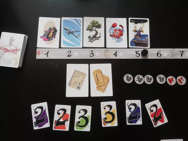 Ensemble - Colorful rectangular game cards with numbers, animal, and object illustrations, plus round and rectangular tokens on black.