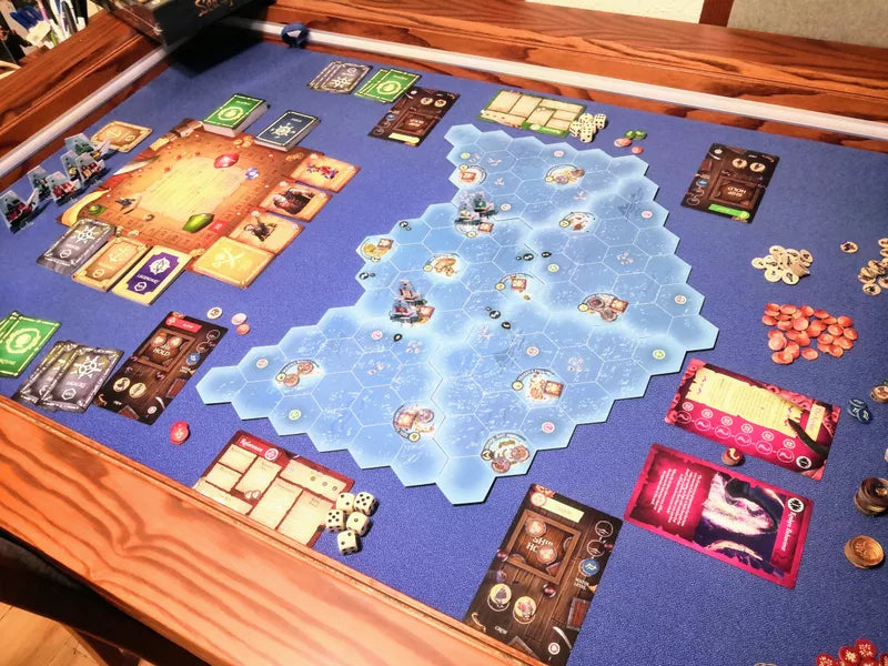 Sea of Thieves: Voyage of Legends - Board game setup with a nautical-themed map featuring islands, surrounded by cards, tokens, and player boards on a wooden.