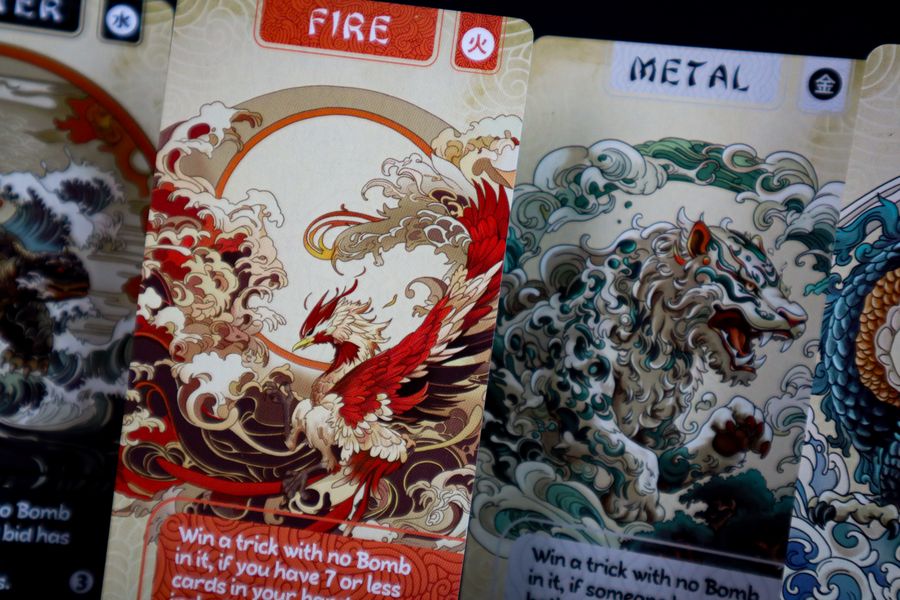 Panda Spin (PREORDER) - Card game cards featuring intricate red fire phoenix and blue metal dragon artwork with swirling cloud patterns.