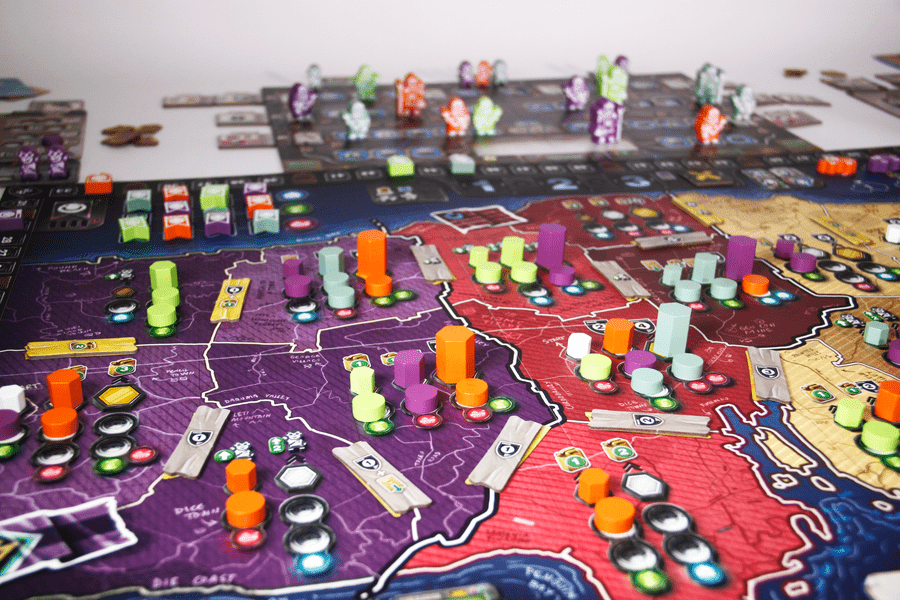 Phoenix New Horizon - Colorful strategy board game with map regions in purple, red, and orange, featuring orange, green, and purple player tokens.