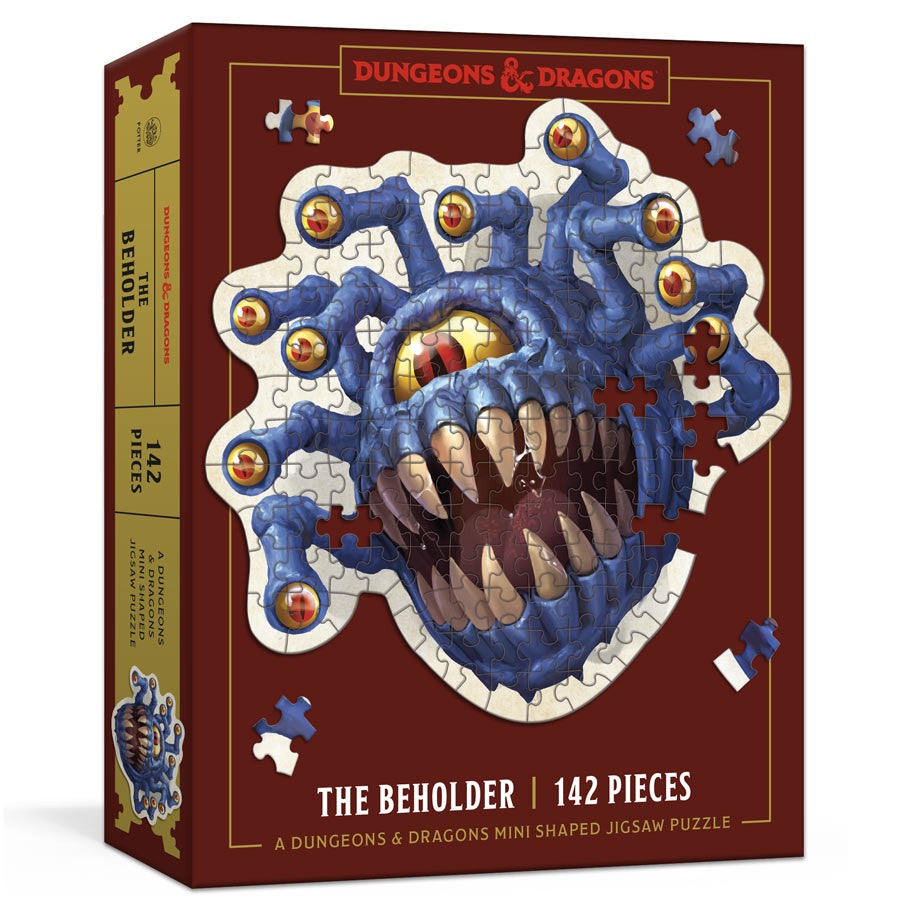 D&D Mini Beholder 102 Piece Puzzle - Dungeons & Dragons puzzle box featuring a blue Beholder with sharp teeth and multiple eye stalks, 142 pieces on a red.