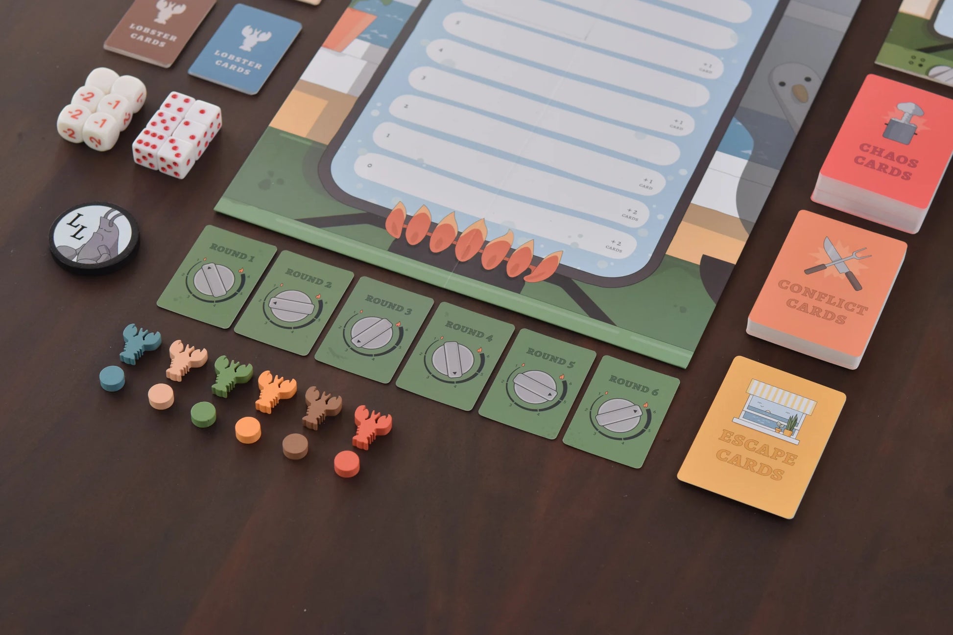 Lobster Pot - Rectangular game board with blue score sheet, colorful cards, custom dice, and small orange and green lobster-shaped game.