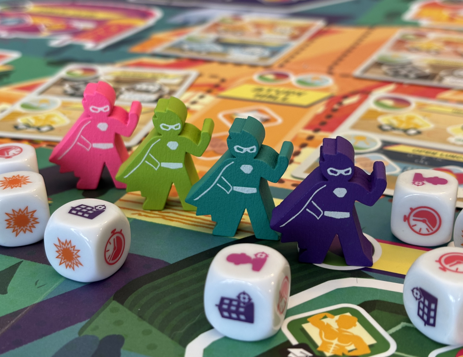 Super Squad High - Colorful cardboard character tokens in pink, green, teal, and purple on a vibrant game board with illustrated spaces and.